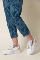 Zapatillas urbanas de cuero vacuno color beige, con detalles en verde oliva y rosa pastel.