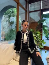 Campera blanca de algodón con bordados florales en color crema, corte recto y mangas acampanadas.