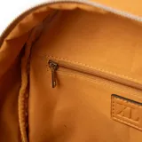Mochila pequeña color suela de cuero sintético, con cierre superior y bolsillo frontal con cierre. Tiene un asa de mano y correas regulables para los hombros.