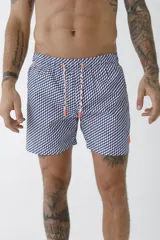 Short de baño color salmón con estampado de hojas de palmera en tonos beige.