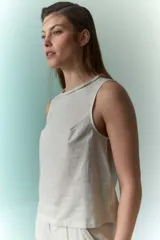 Top sin mangas de lino metalizado color beige, con cuello redondo y detalle trenzado en el borde.