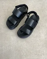 Sandalias con plataforma color marrón con textura de piel de reptil, con dos tiras anchas sobre el empeine y tira trasera ajustable.