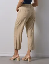 Pantalón color beige, marca Dash, de corte cropped y pretina trasera elastizada. Presenta bolsillos delanteros y traseros.