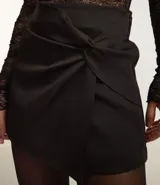Short pollera blanco de sastrería con nudo sobrepuesto delantero.