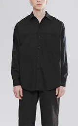 Camisa negra de manga larga con bolsillo con ojal y botón en el delantero, de calce oversize confeccionada en tejido plano fresco y liviano.