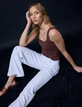 Pantalón de jean blanco de pierna ancha, tiro alto, pretina con pasadores, botón y cierre. Delantera y trasera con bolsillos.