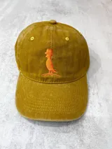 Gorro color mostaza con bordado de logo anaranjado en la parte frontal.