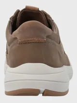 Zapato acordonado de cuero marrón con suela blanca de goma.