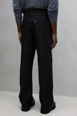 Pantalón de jean negro de tiro alto, corte relajado y pierna ancha.