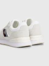 Zapatillas Tommy Hilfiger blancas con detalles en gamuza y la cinta distintiva de la marca en el lateral.