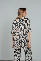 Remerón de tela tejida con estampado animal print en tonos rosa y negro, cuello alto y mangas cortas.