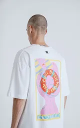 Remera blanca de algodón con estampa sublimada de una figura femenina sosteniendo un salvavidas con la frase "Chill Bitch Trust Karma" y el texto "The Wheel of Fortune". Corte oversize y cuello redondo.