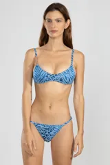 Bombacha de bikini de cobertura mínima con tiras laterales ajustables, confeccionada en tejido jacquard con hilos de lurex y charm de tigre insignia de Polonio en el lateral derecho.