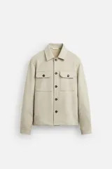 Sobrecamisa color beige de corte recto, con cuello solapa, manga larga con puños abotonados, cierre frontal abotonado, bolsillos de parche con solapa en el pecho y bolsillos de ojal en la cadera.