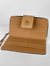 Billetera grande de cuero tricolor: negro, blanco con textura de cocodrilo y marrón claro. Tiene cierre de cremallera, correa de mano y botón de cierre con logo de búho.