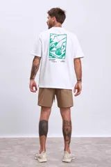 Remera marrón de manga corta y cuello redondo, con un pequeño estampado blanco de una cafetera moka en el pecho.