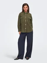 Camisa verde militar de pana con corte oversize, cuello clásico, cierre frontal con botones, mangas largas con puños abotonados, bolsillos de parche en el pecho y forro de jersey de algodón.