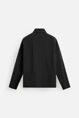 Sobrecamisa color crema de tejido técnico ligero, corte regular fit, cuello solapa, manga larga con puños abotonados, bajo ajustable con elástico en laterales y cierre frontal con cremallera.