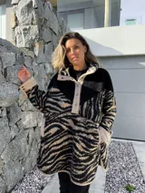 Buzo de polar con cuello alto, cierre de botones a presión y estampado de cebra en tonos beige y negro.