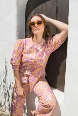 Camisa de lino estampada con flores en tonos rosa y naranja, con cuello mao, mangas cortas abullonadas y cierre frontal con botones.