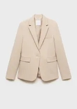 Blazer color beige con solapas de muesca, cierre frontal con un botón, hombros estructurados, corte entallado, forro interior y dos bolsillos de ribete en la parte delantera.