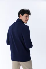 Sweater azul marino de punto con cuello cruzado y cierre de un botón.