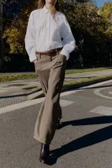 Pantalón cargo de tiro alto color marrón topo, con pierna ancha y holgada que se estrecha hacia el tobillo. Presenta bolsillos delanteros, bolsillo de plastrón lateral y falso bolsillo de vivo en la espalda.