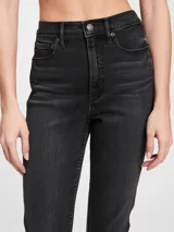 Pantalón de jean negro con tiro alto, corte slim y terminación desflecada.