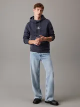 Buzo de felpa azul marino con capucha y cordones ajustables. Logotipo de Calvin Klein Jeans estampado en el pecho.