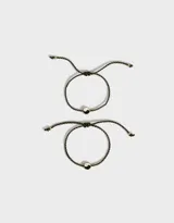 Set de dos pulseras con cordón ajustable y dije de yin yang.