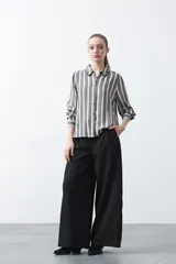 Camisa de manga larga color marrón con estampado de lunares blancos, confeccionada en tejido liviano con cuello clásico y botones frontales.