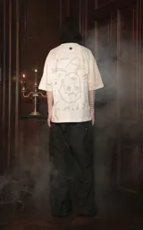 Remera blanca de algodón con cuello redondo y calce oversize. Estampa en el frente con diseño de la carta del tarot 'El Colgado' y la leyenda 'Tarot x Luxo'.