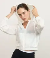 Campera deportiva estilo rompevientos cropped, color blanco, con capucha y cierre frontal.