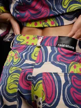 Pantalón de gabardina carrot fit estampado con diseño floral en tonos vibrantes, tiro medio y detalles personalizados.