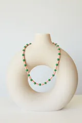 Collar corto tipo choker de cuentas plásticas amarillas y tubos de plástico verde.