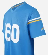 Remera deportiva azul con cuello en V y mangas cortas con rayas blancas y doradas. Estampado frontal con el logo de Los Angeles Chargers, el número 60 y la inscripción "est.". Confeccionada con tecnología Dry para mayor transpirabilidad.