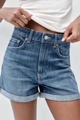 Bermuda de jean celeste, tiro alto, corte mom fit, con trabillas y cinco bolsillos.