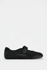 Zapato tipo bailarina color negro, con capellada de cuero sintético y rejilla. Tiene tira con velcro en el empeine y suela plana.