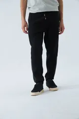 Pantalón de jogging gris oscuro de felpa con puños, cintura ajustable con cordón y logo estampado en la pierna.