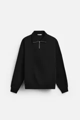Sudadera negra de cuello alto con cierre frontal de cremallera, corte relaxed fit, manga larga y terminaciones en rib.