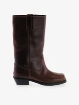 Bota de caña media color marrón oscuro, estilo vaquero, confeccionada en cuero. Presenta punta cuadrada y taco bajo y ancho.