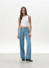 Pantalón de jean celeste con rayas verticales, tiro bajo y corte wide leg.