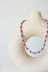 Collar corto tipo choker de cuentas plásticas amarillas y tubos de plástico verde.