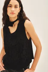 Musculosa blanca de encaje con cuello redondo.