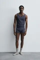 Conjunto de pijama color gris compuesto por una camiseta sin mangas de corte ajustado y un bóxer corto con cintura elástica y botones.