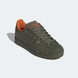 Championes urbanos Adidas Superstar II de color verde militar con forro interno naranja. Cuentan con un exterior de cuero con detalles de nylon abullonado, la clásica puntera de goma con relieve y suela de caucho a tono.