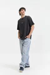 Remera marrón de manga corta con cuello redondo y estampado en la espalda con motivos geométricos y el logo de la marca Mistral.
