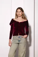 Remera color bordó de terciopelo con escote bardot y mangas largas.