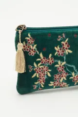 Bolso mini de terciopelo color verde con bordado de flores rojas y amarillas. Tiene cierre con borla.