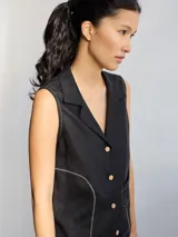 Chaleco negro con cuello solapa, abotonado al frente y con pespuntes en color crudo.